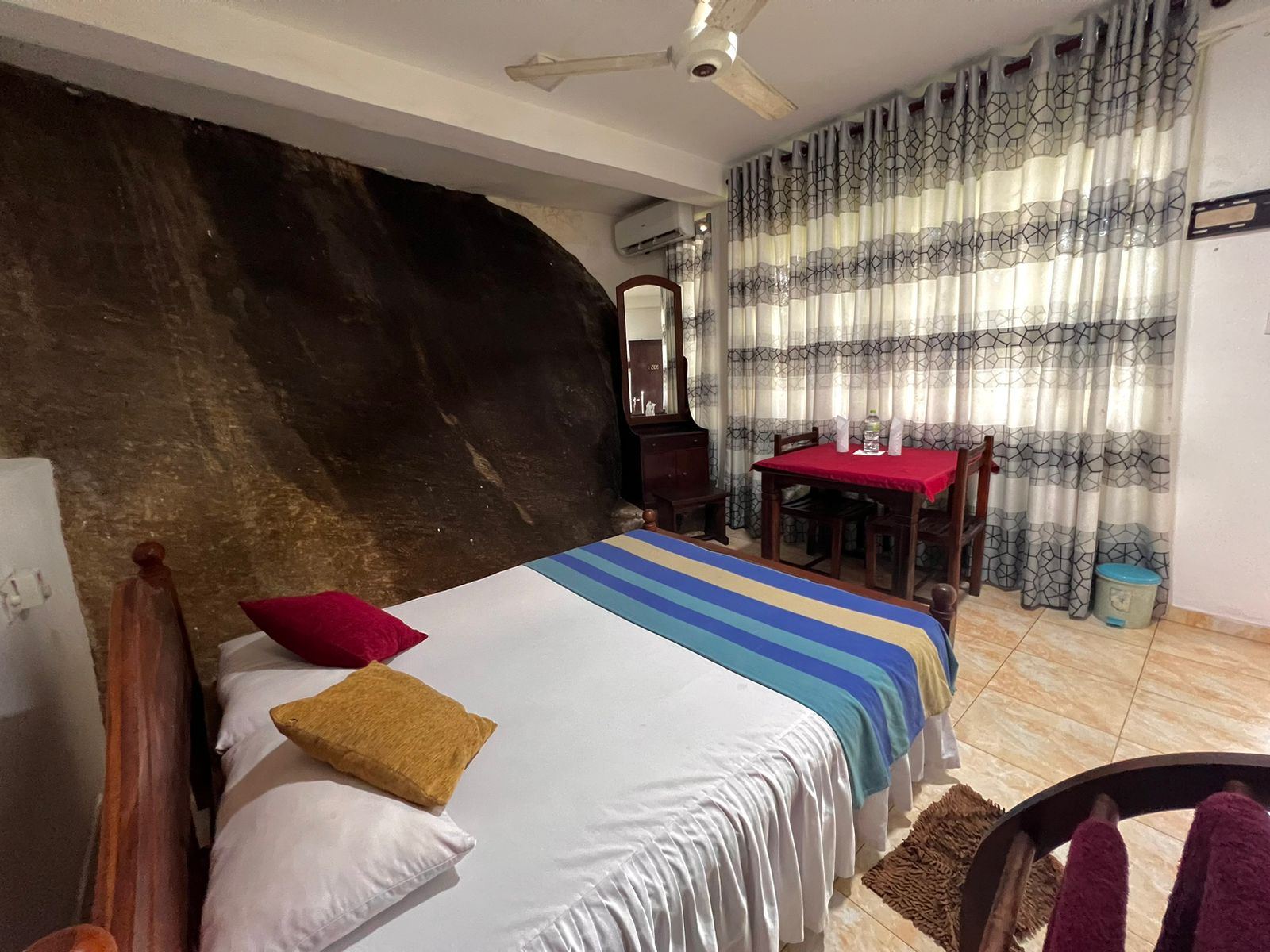 Bright room with a boulder wall and striped bedding