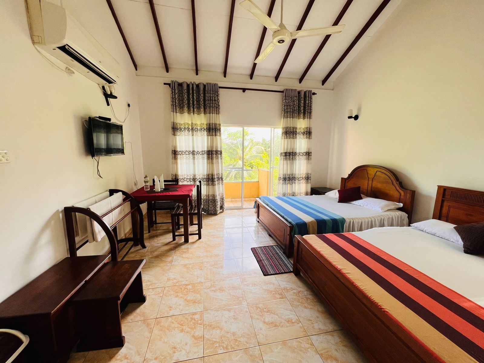 Room with timber vaulted ceiling and doors to a balcony